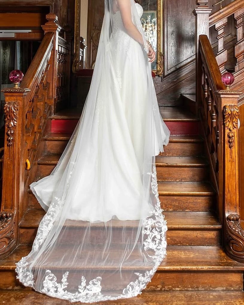 Une mariée dans un escalier, le voile en traîne